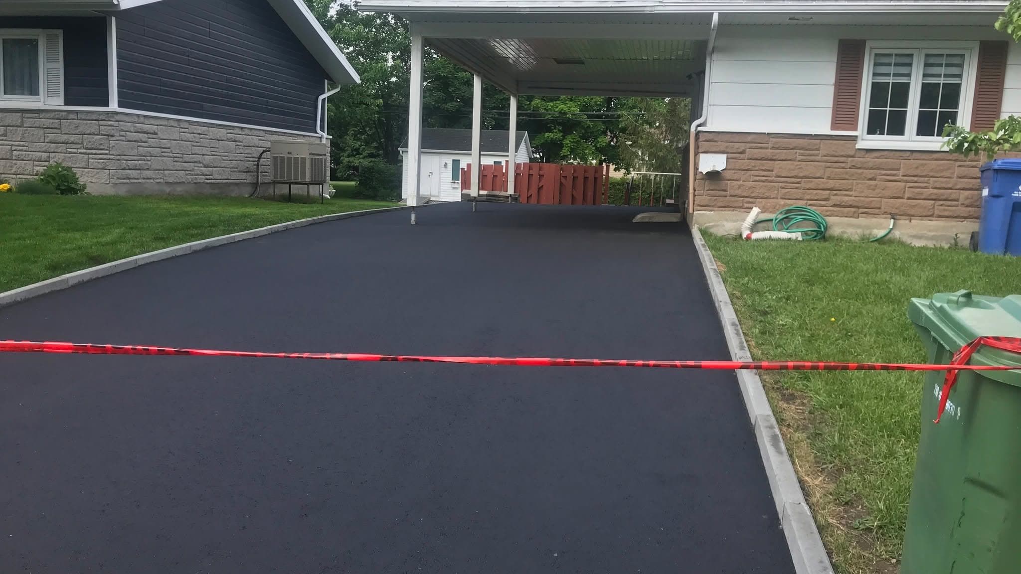Pose et compaction d'asphalte neuf sur un chantier résidentiel PAVEX à Québec.
