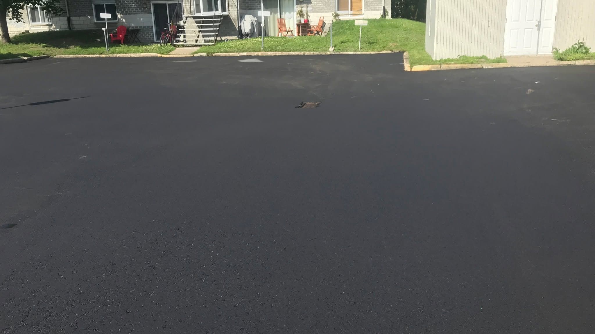 Nouvelle couche d'asphalte étendue sur une surface existante par l'équipe PAVEX.